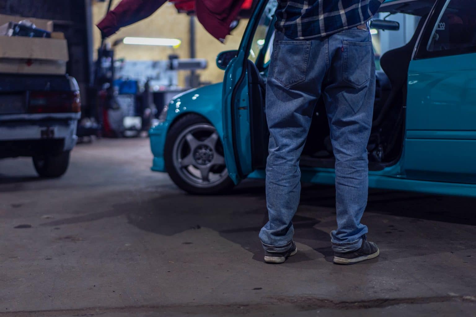 Man in garage die auto uitdeukt